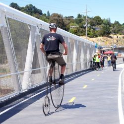 man riding a high-wheel bicycle on central marin ferry connector