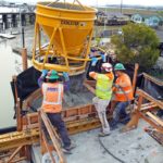 Workers pour concrete into a new pier